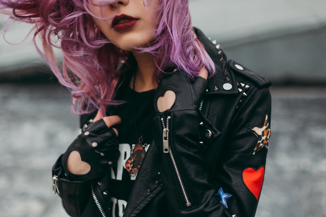 Stylish woman with purple hair in a studded leather jacket. Edgy and modern fashion.